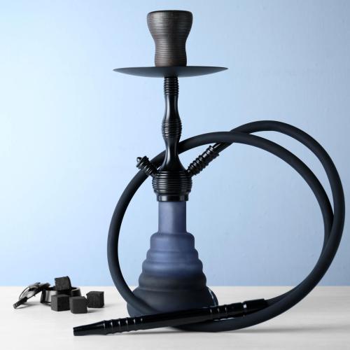 Traditional hookah on white table against light blue background