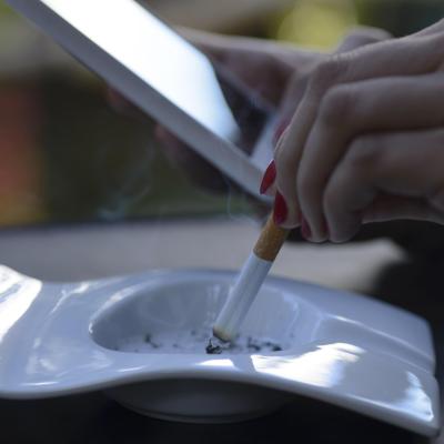 hand-holding-mobile-phone-near-smoking-cigarette-2026-03-26-07-19-19-utc